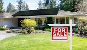 House with for sale sign in front yard